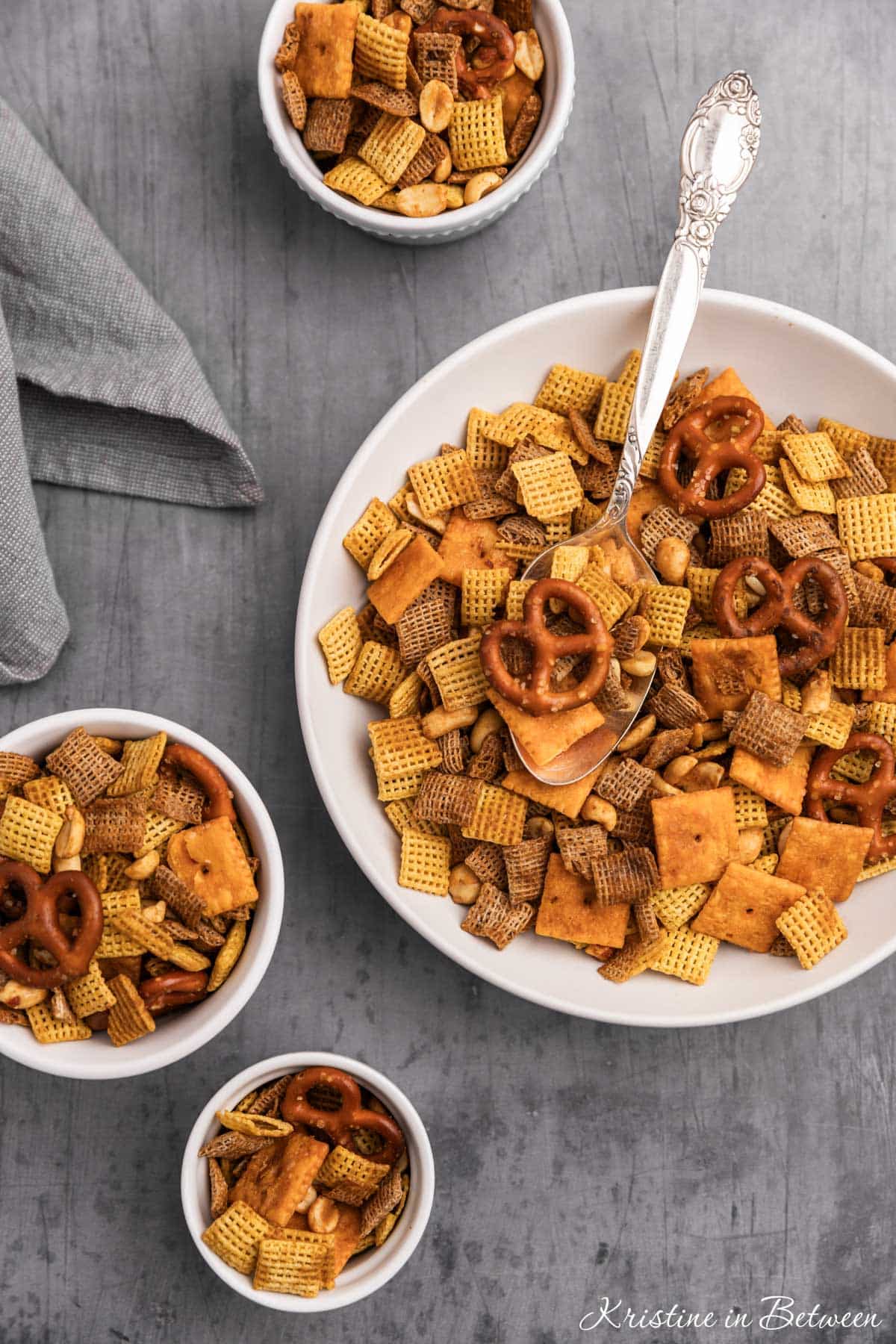 Snack mix in bowls with an antique spoon.