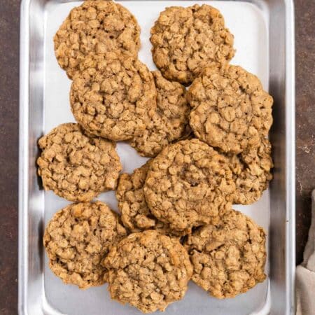 Old-fashioned oatmeal walnut cookies sitting on a baking sheet.