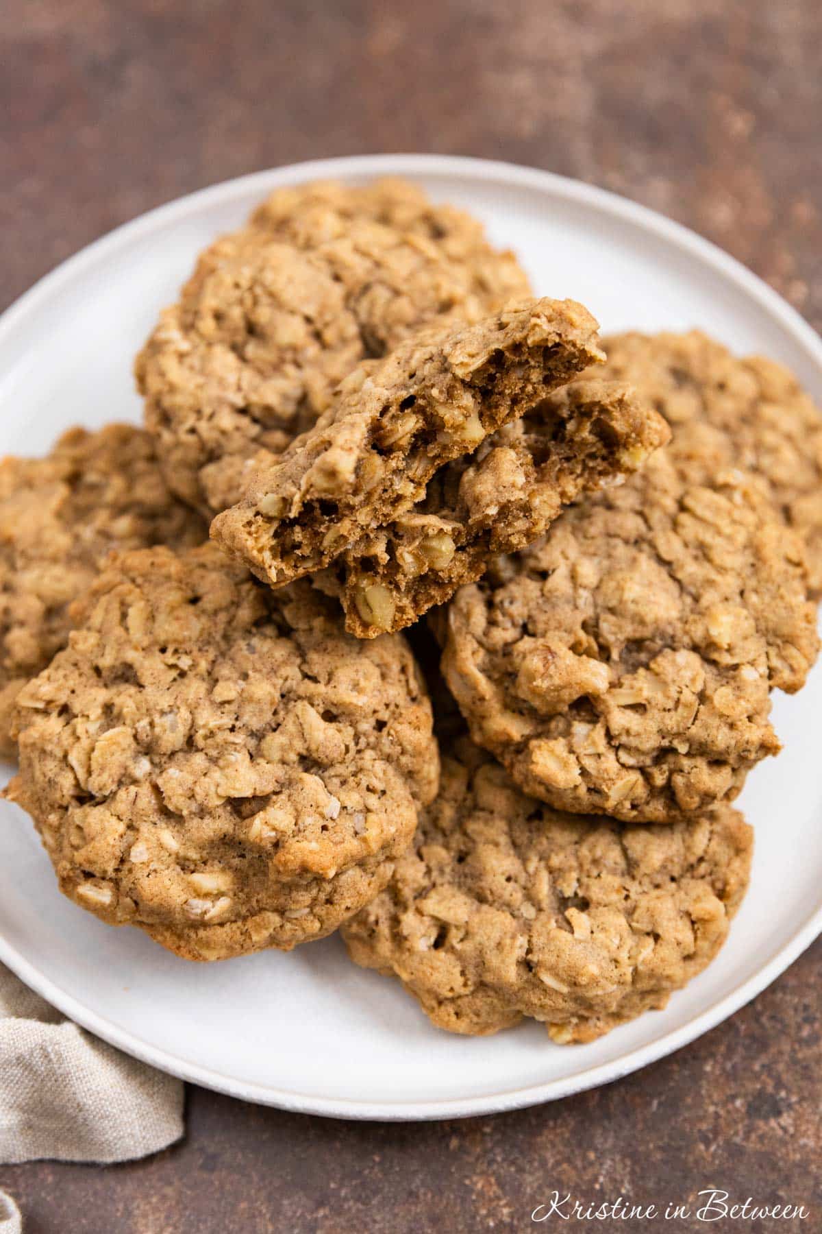 Oatmeal walnut cookies stacked up on a white plate.