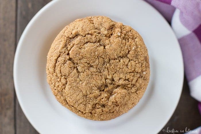 A stack of pumpkin ginger molasses cookies on a white plate with a purple checked napkin.