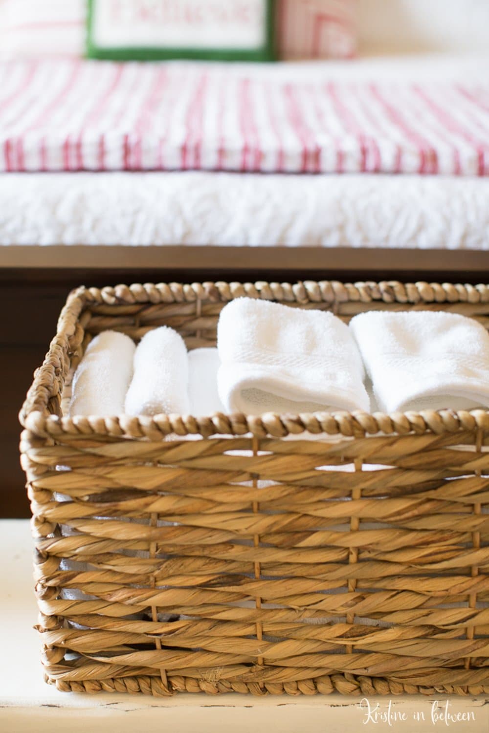 White towels folded up in a woven basket. 
