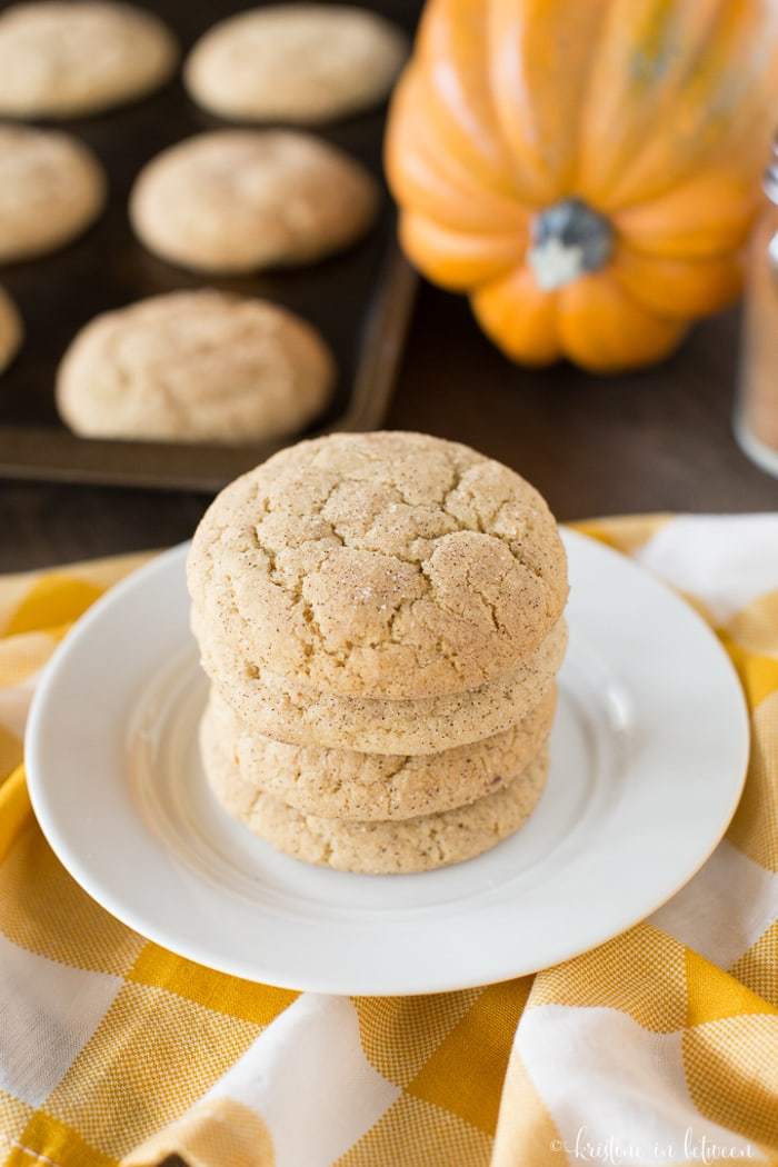 Cookies stacked up on a plate with a yellow and white checkered napkin.