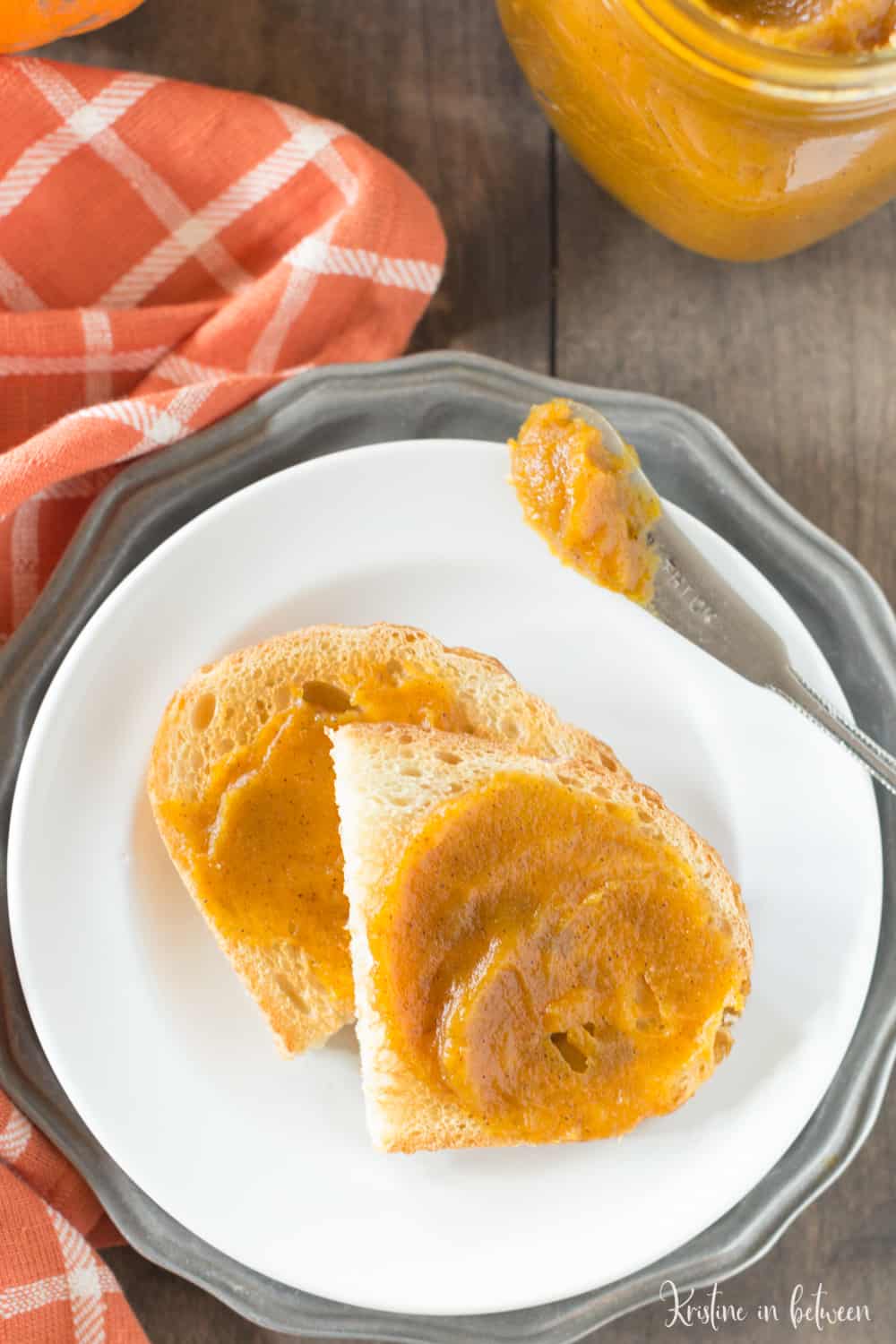 Pumpkin butter smeared on a piece of toast with a knife next to it.