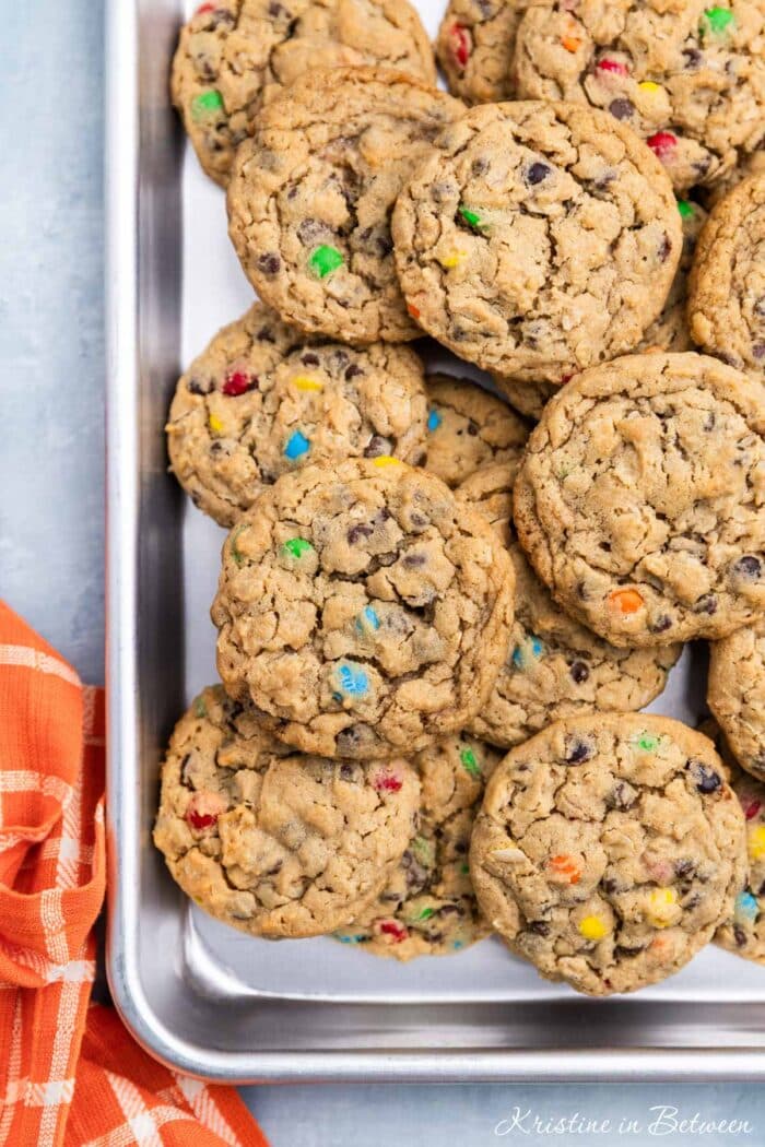 A whole tray of monster cookies sitting with an orange napkin.