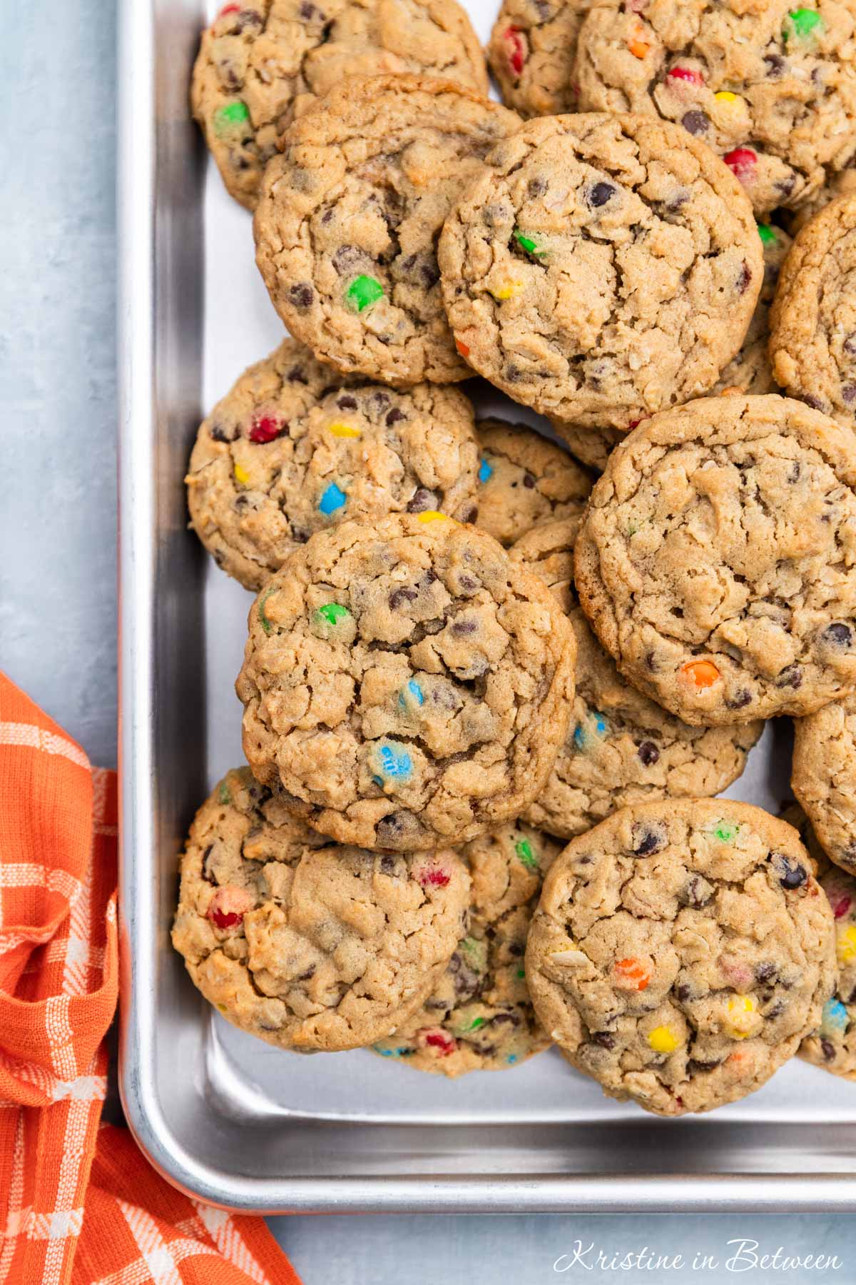 A whole tray of monster cookies sitting with an orange napkin.