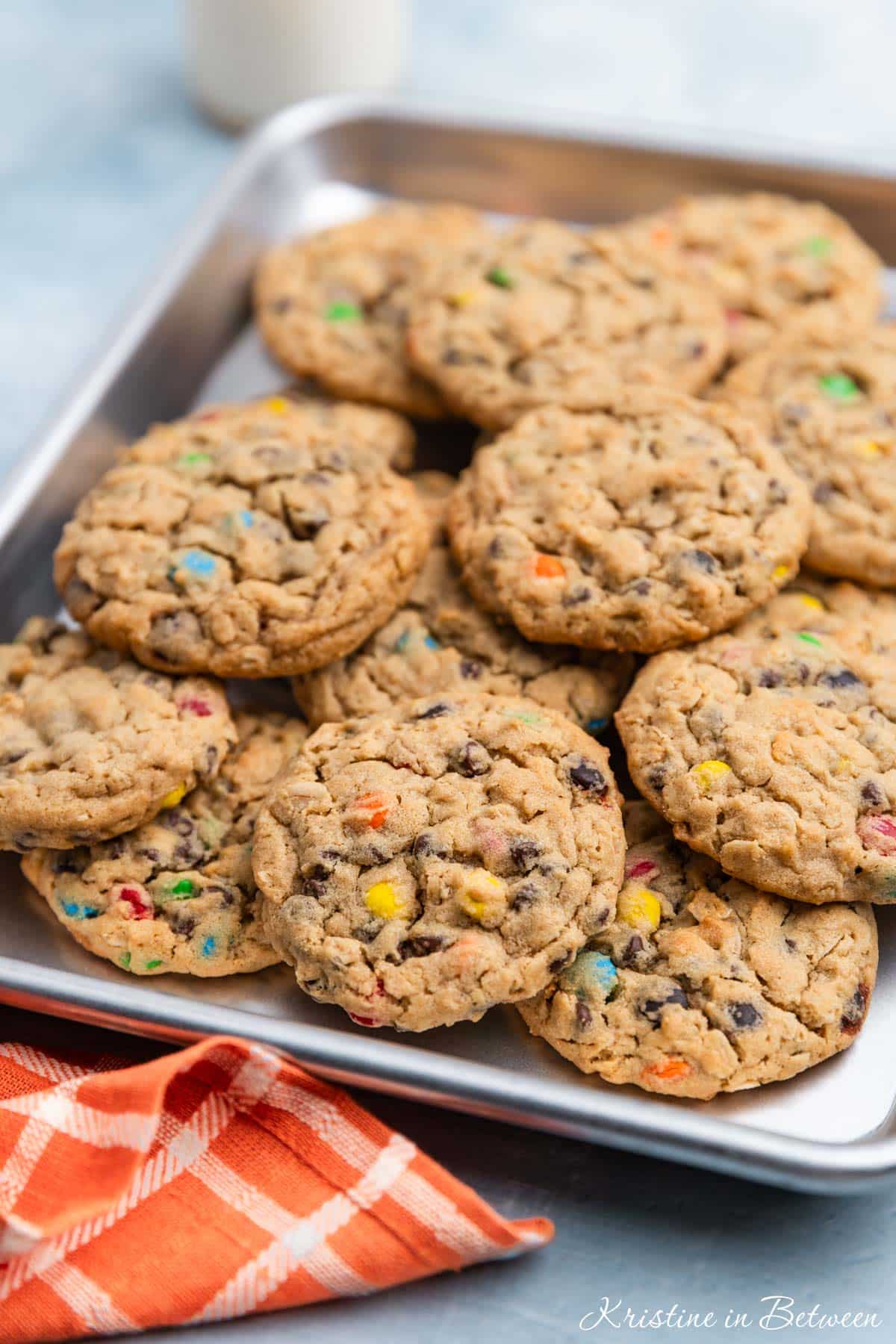 A whole tray of monster cookies sitting with an orange napkin.