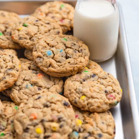 A whole tray of monster cookies sitting with an orange napkin.