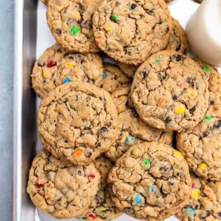 A whole tray of monster cookies sitting with an orange napkin.