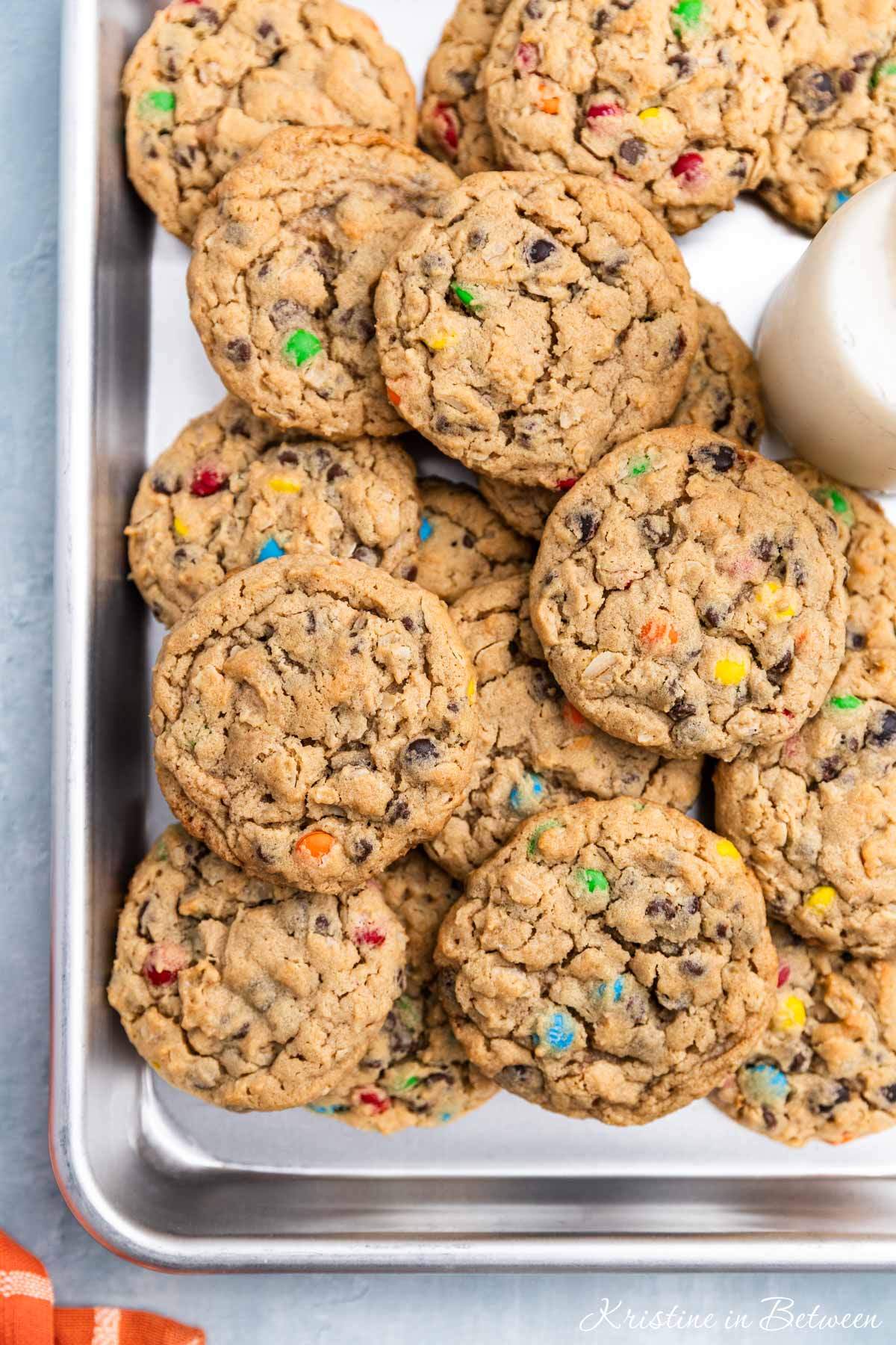 A whole tray of monster cookies sitting with an orange napkin.