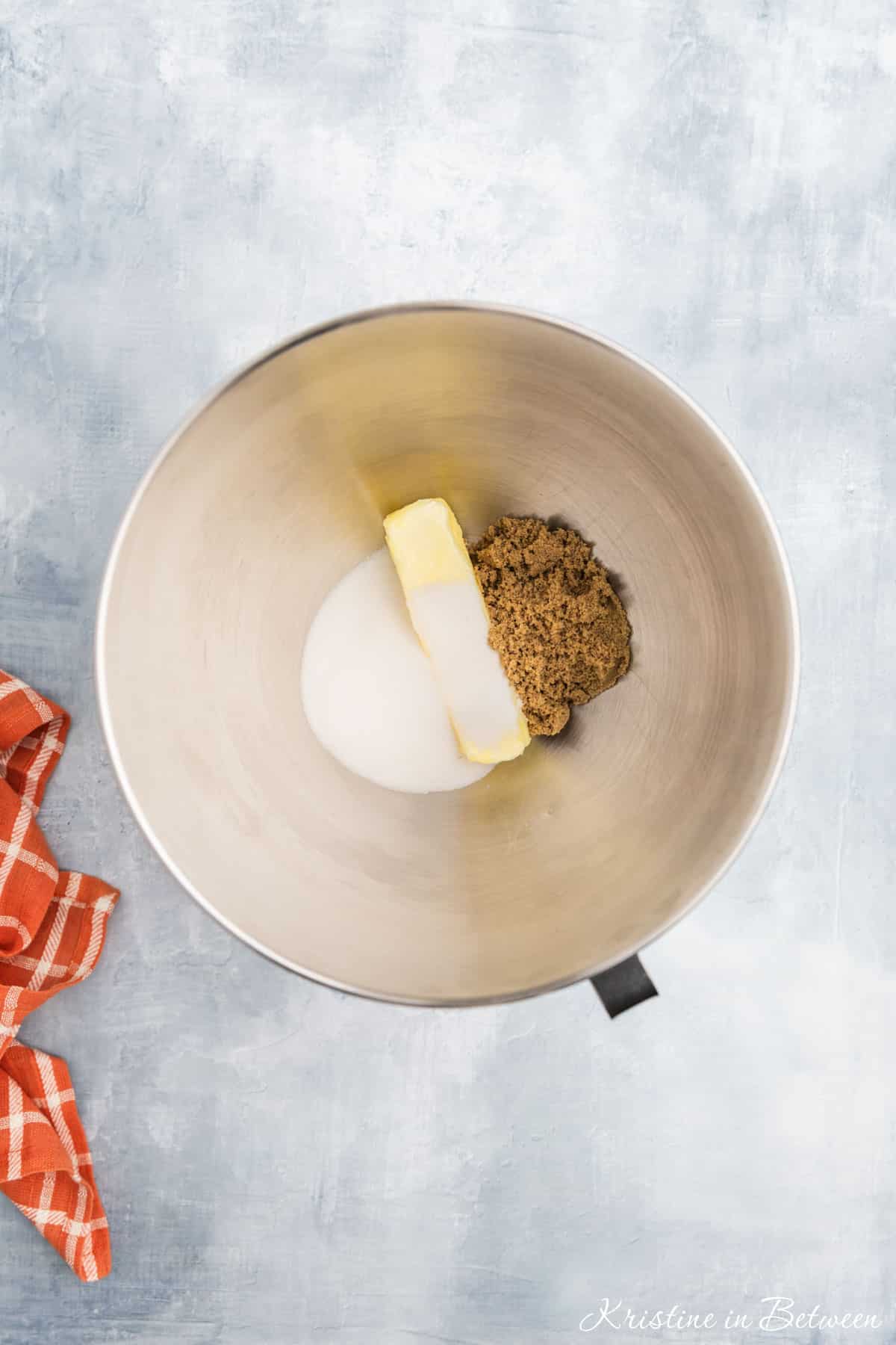 Butter, sugar and brown sugar in the bowl of a stand mixer.