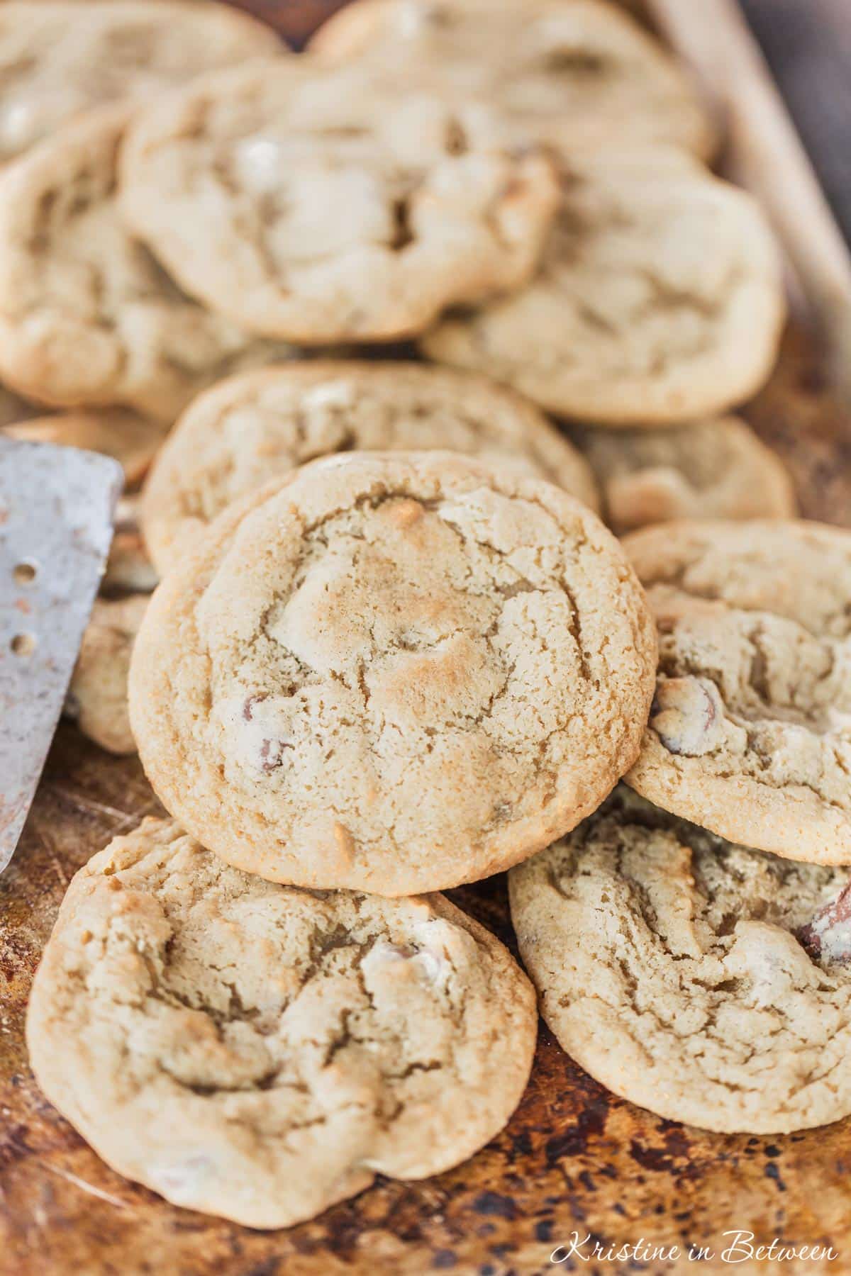 A closeup of a chocolate chip cookie laying on top of other cookies.