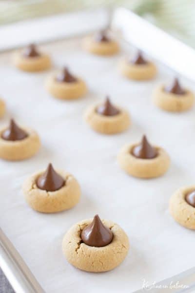 Peanut butter kiss cookies with a green striped napkin in the background