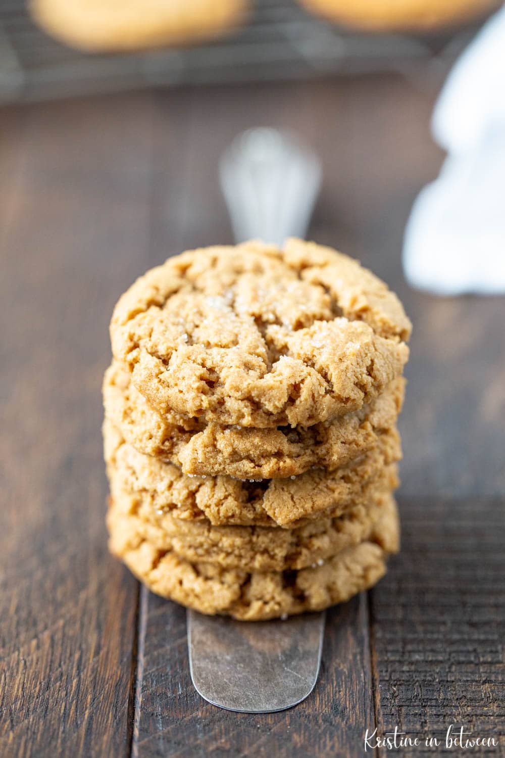 Flourless peanut butter cookies stacked on a wooden board