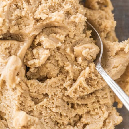 Basic cookie dough mixed up in a glass bowl with a spoon.