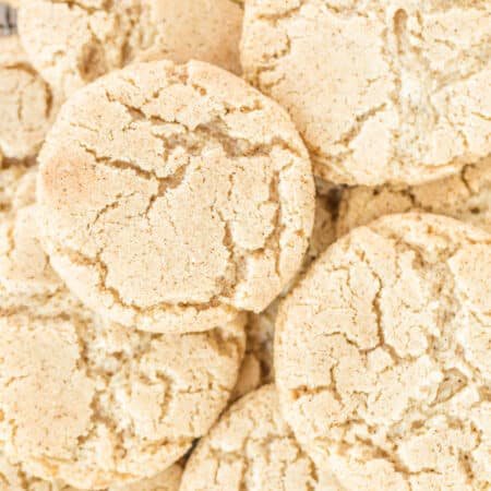 A large pile of cookies with cracked tops.