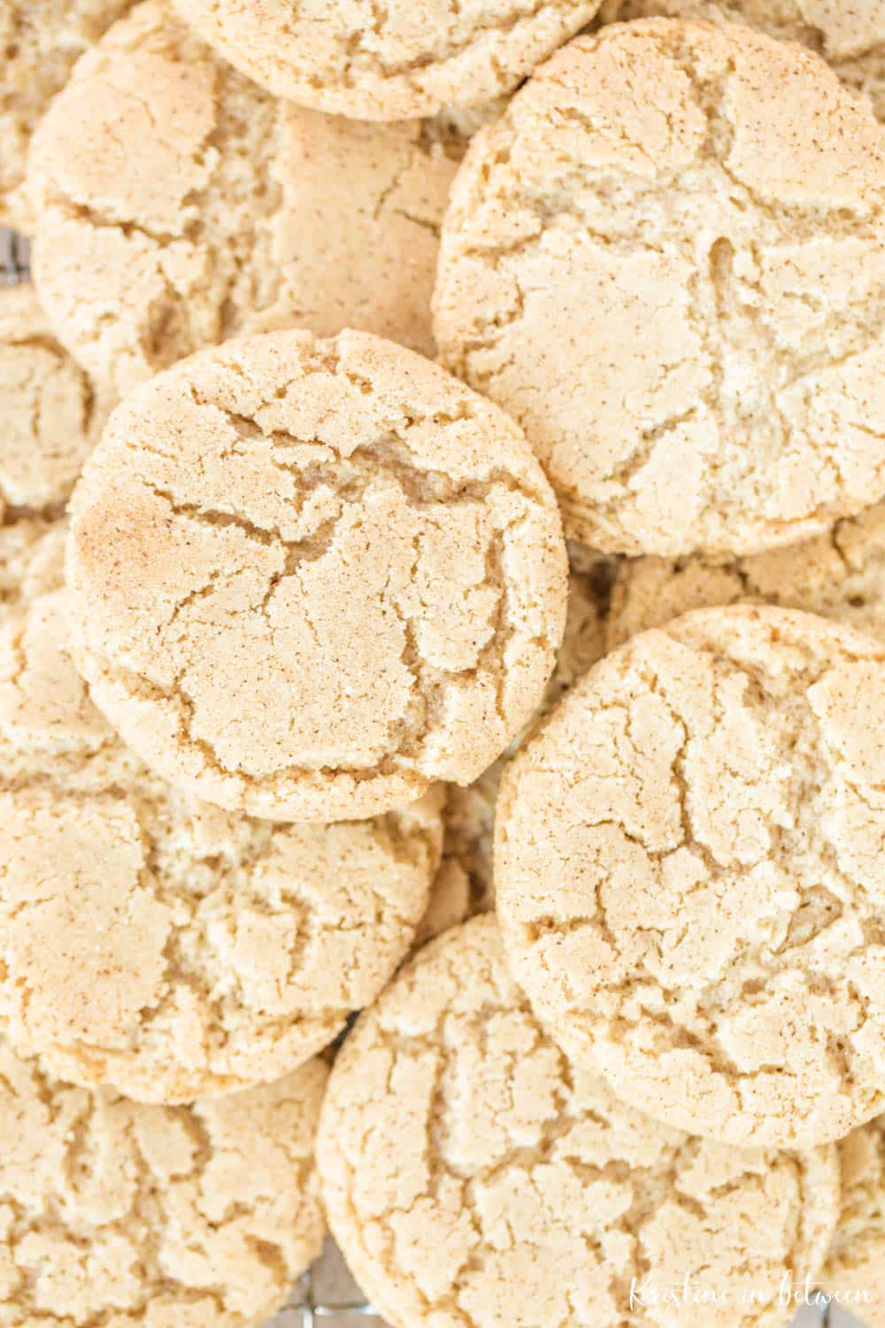A pile of cookies with cracked tops sprinkled with cinnamon and sugar.
