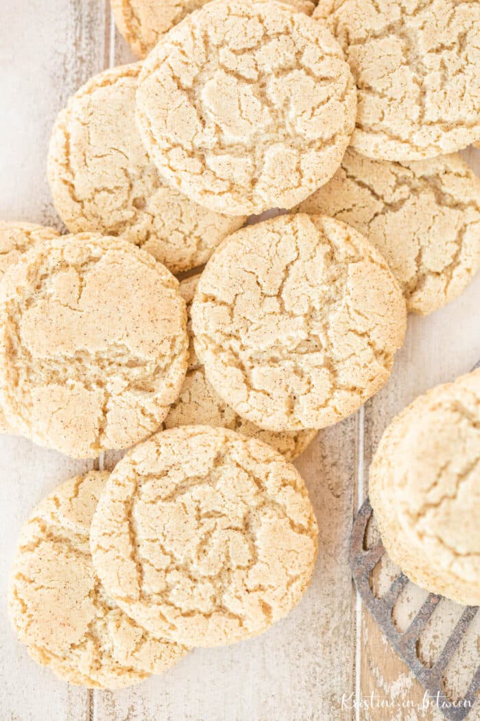 Cookies laying on a white wooden table with an old spatula.