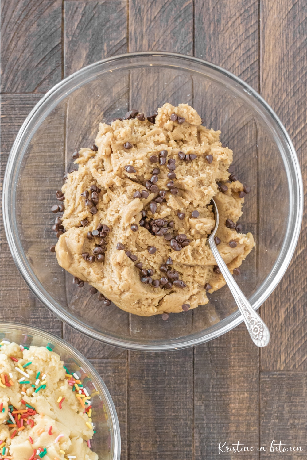 A bowl of cookie dough with chocolate chips and a spoon.
