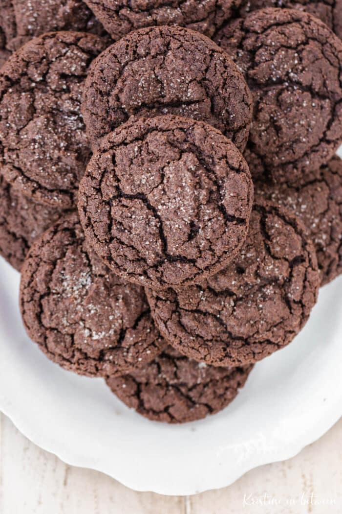 Chocolate cookies piled up on a white platter.