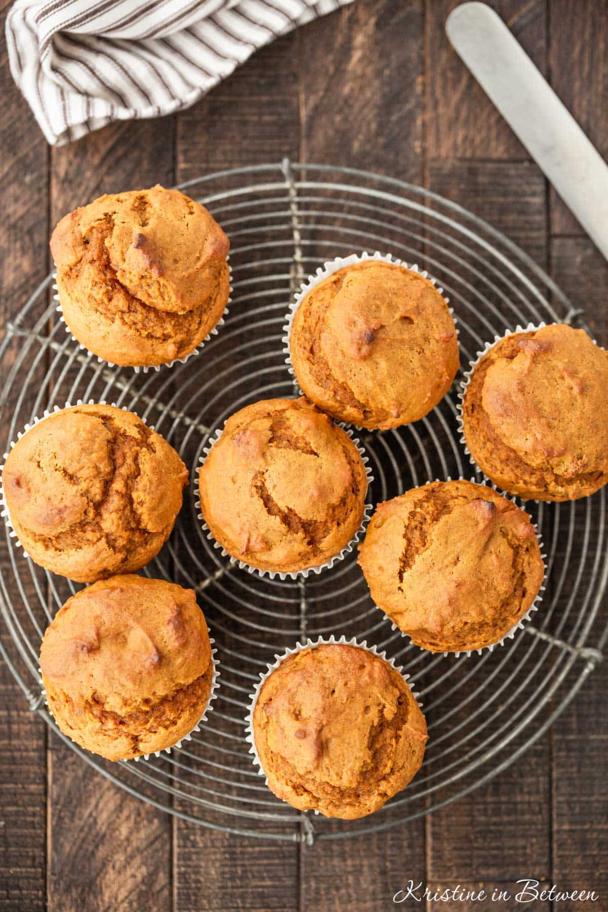 Pumpkin muffins sitting on a wire cooling rack with an antique knife next to them.