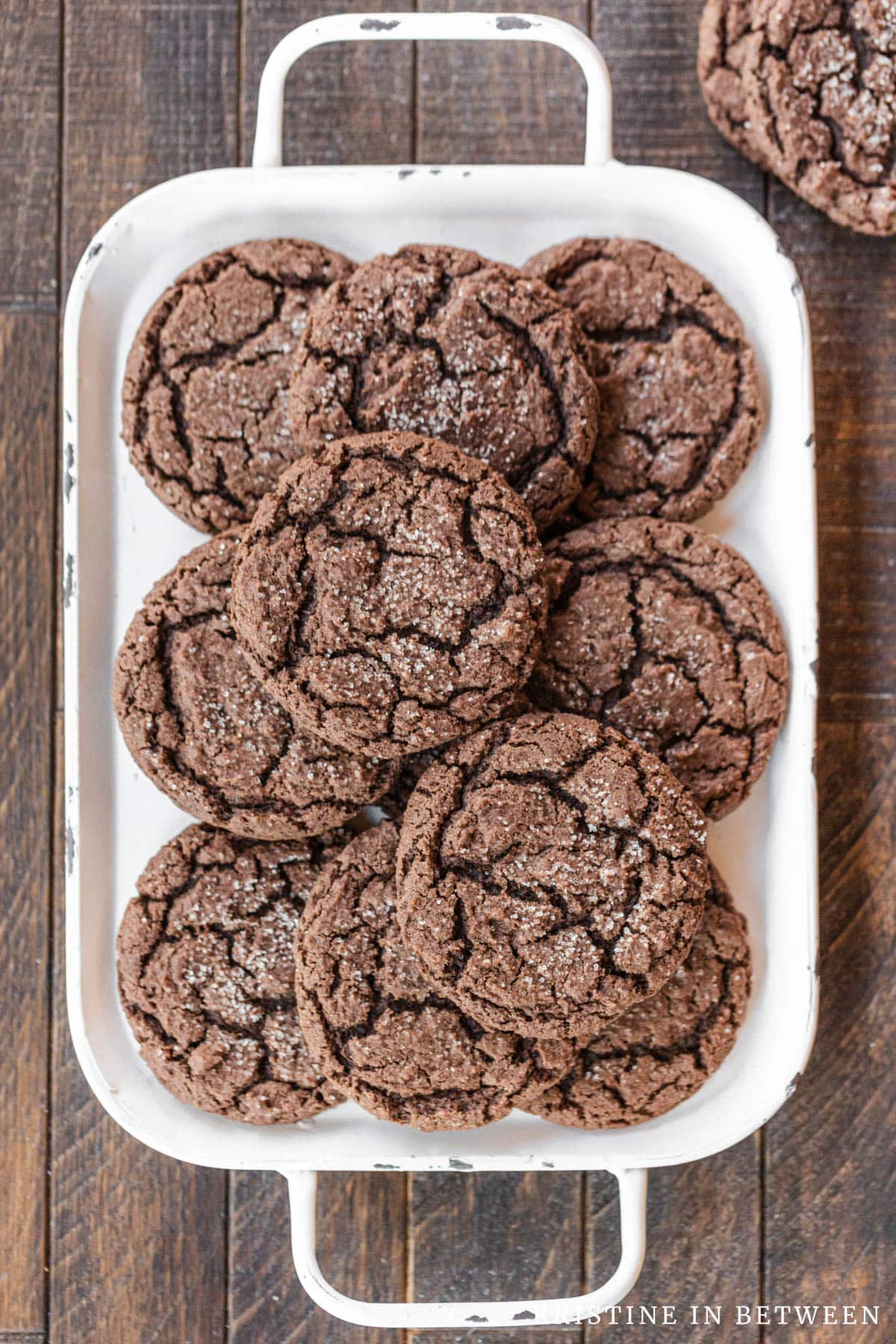 Chocolate cookies stacked up on a white tray.