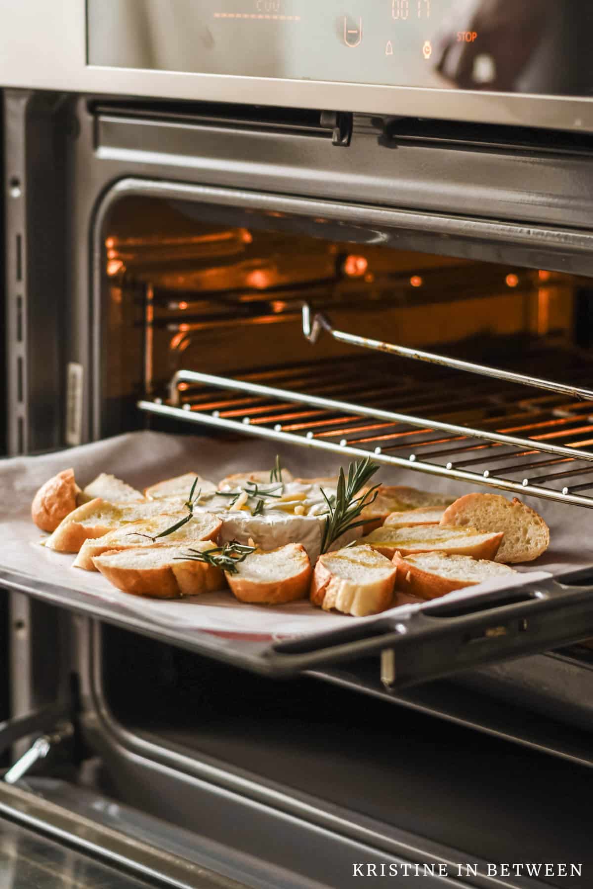 An open oven with a sheet of baked bread sitting on the rack.