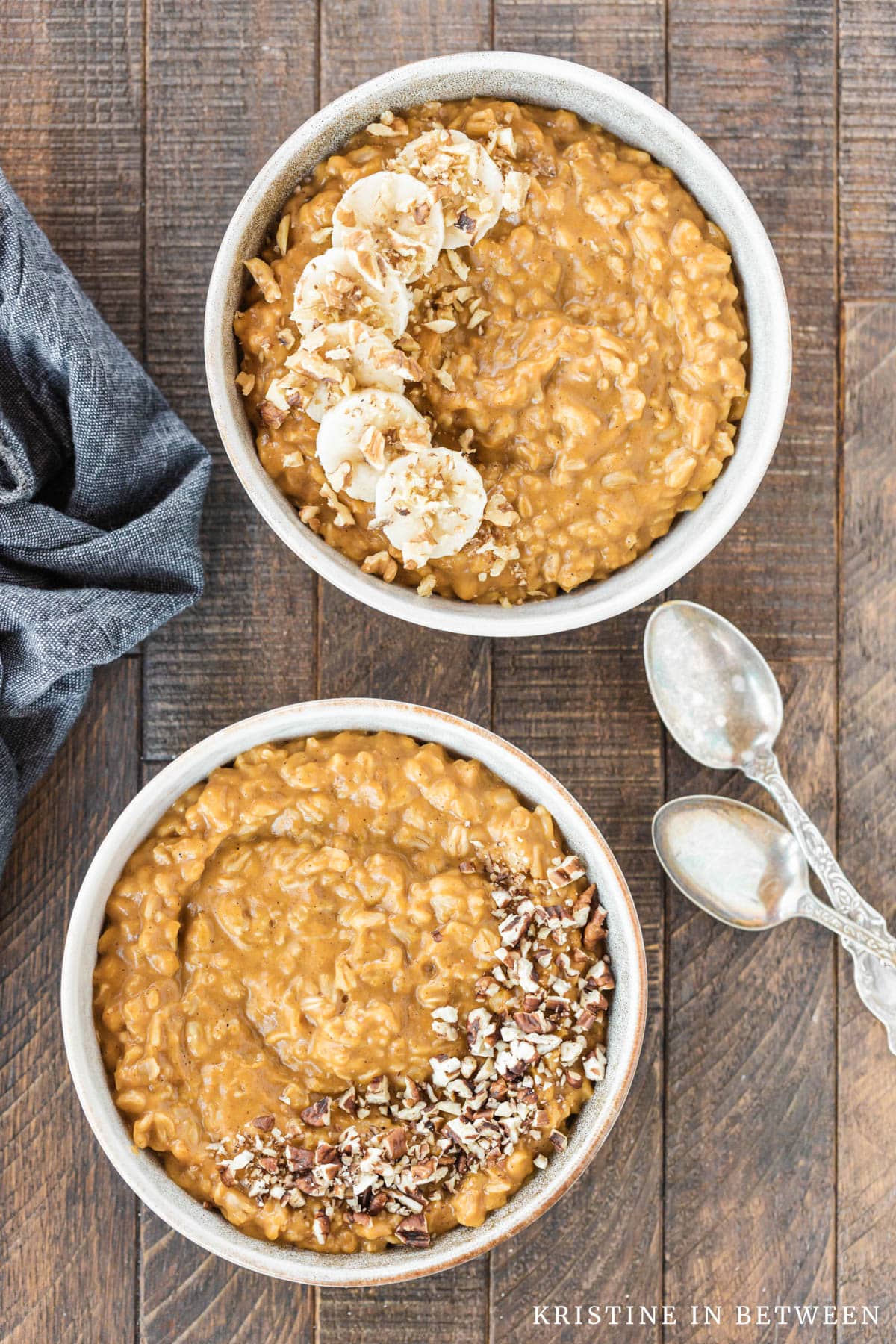 Two bowls of oatmeal, one with pecans and one with bananas and walnuts on top.