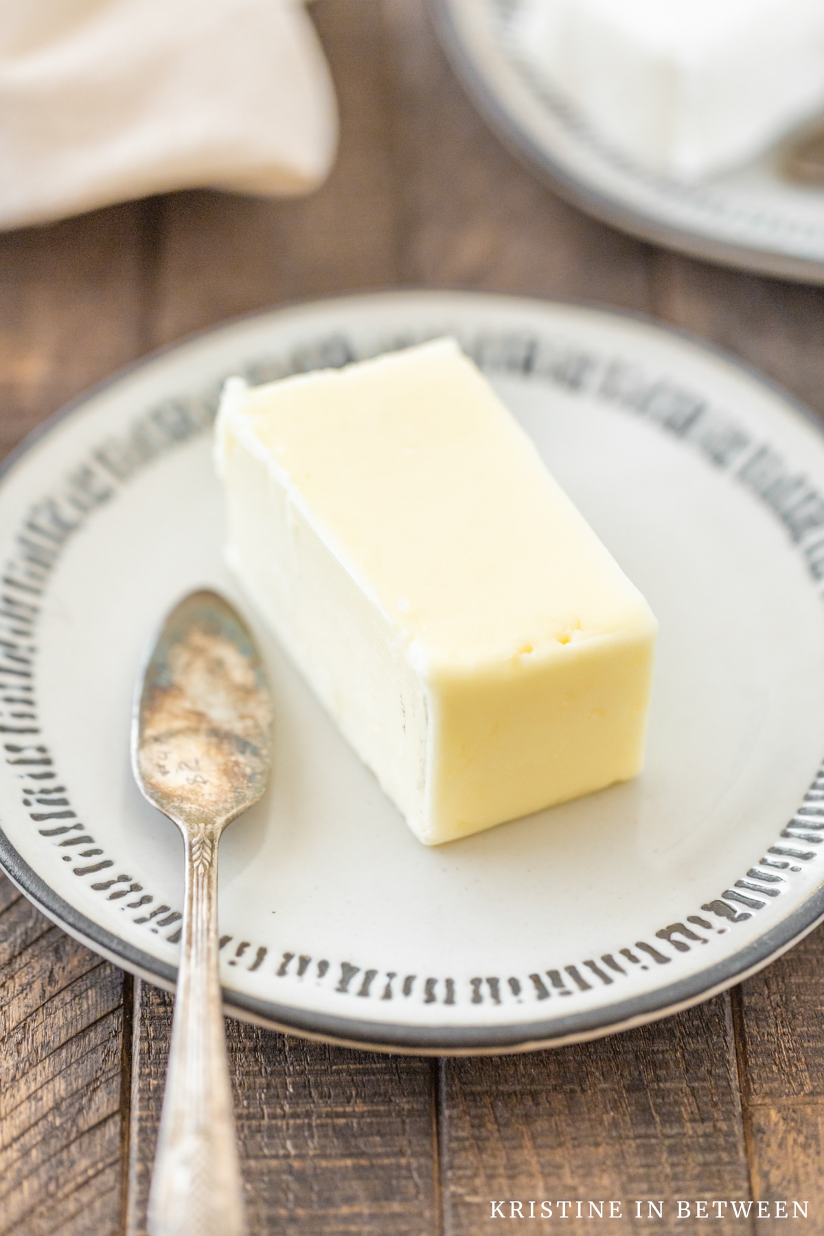 A plate of butter sitting with a butter knife.