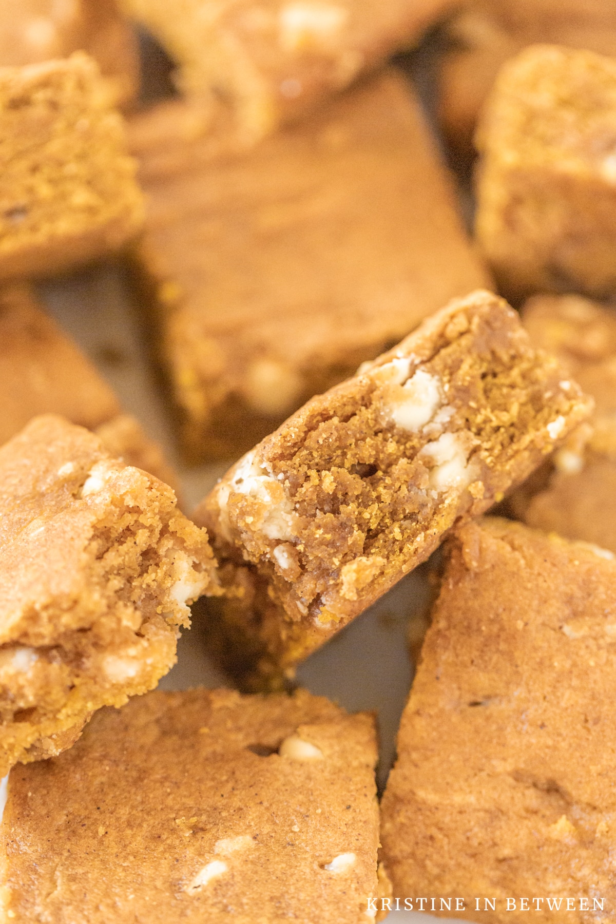 A stack of pumpkin blondies with one turned sideways to show the detail of the inside.