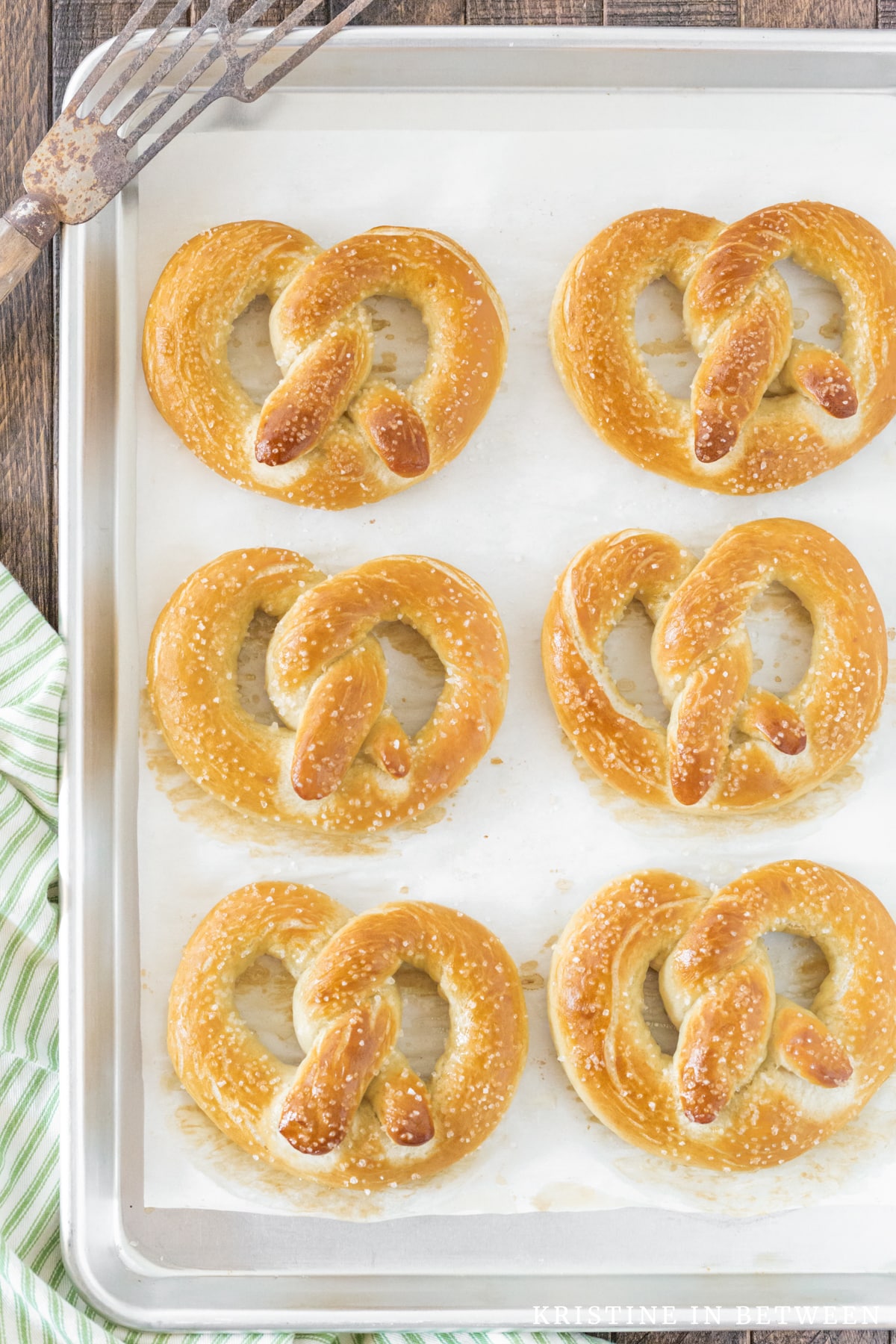 Soft pretzels on a baking pan lined with parchment paper.