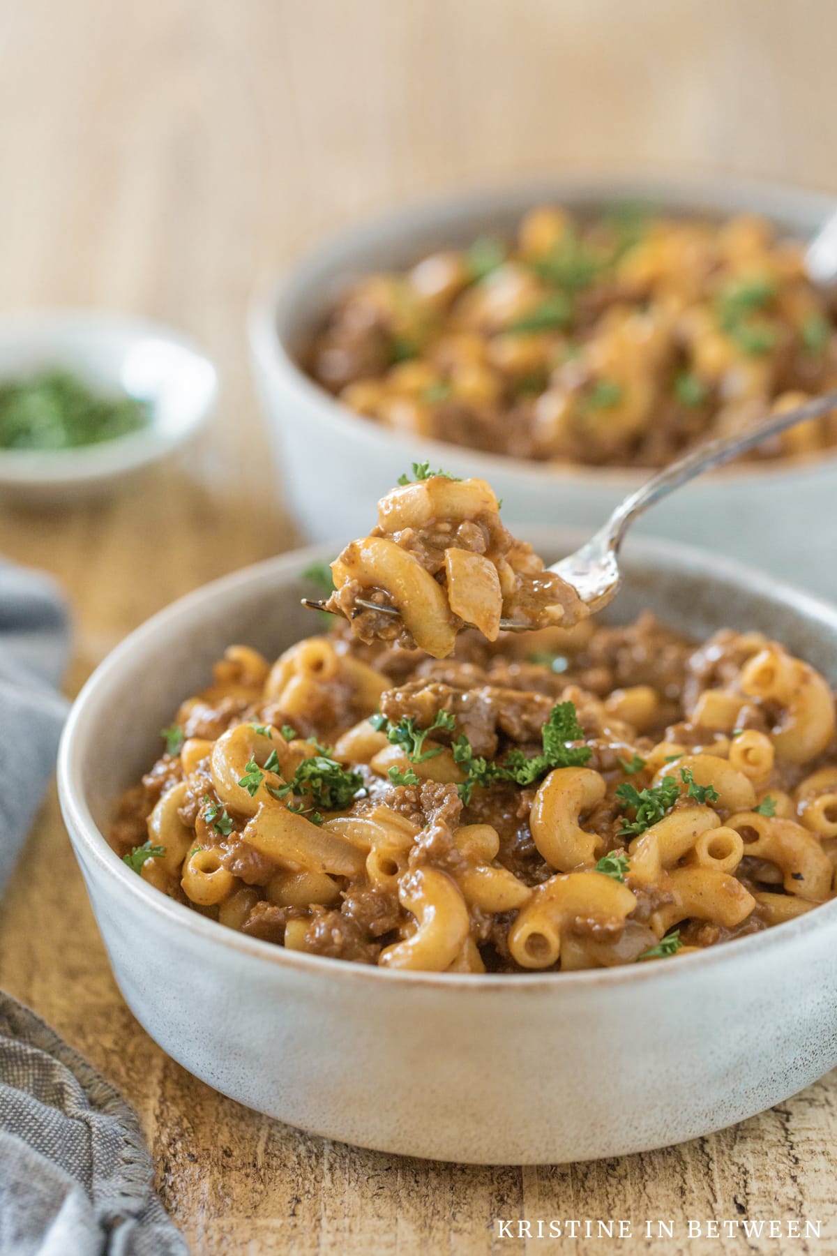 A bowl of homemade chili mac with a bit on a fork ready to go.
