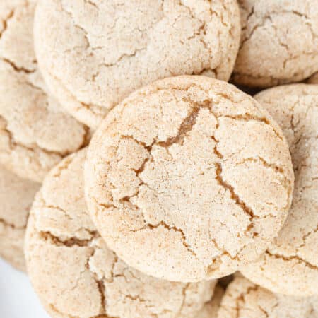 Snickerdoodle cookies stacked up showing the cracked tops.