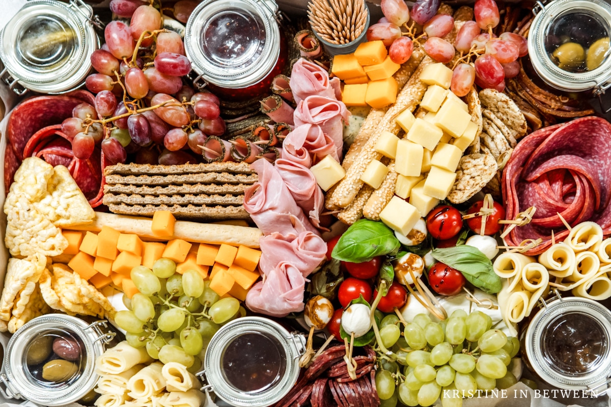 A charcuterie board with meats, fruits, and cheeses.