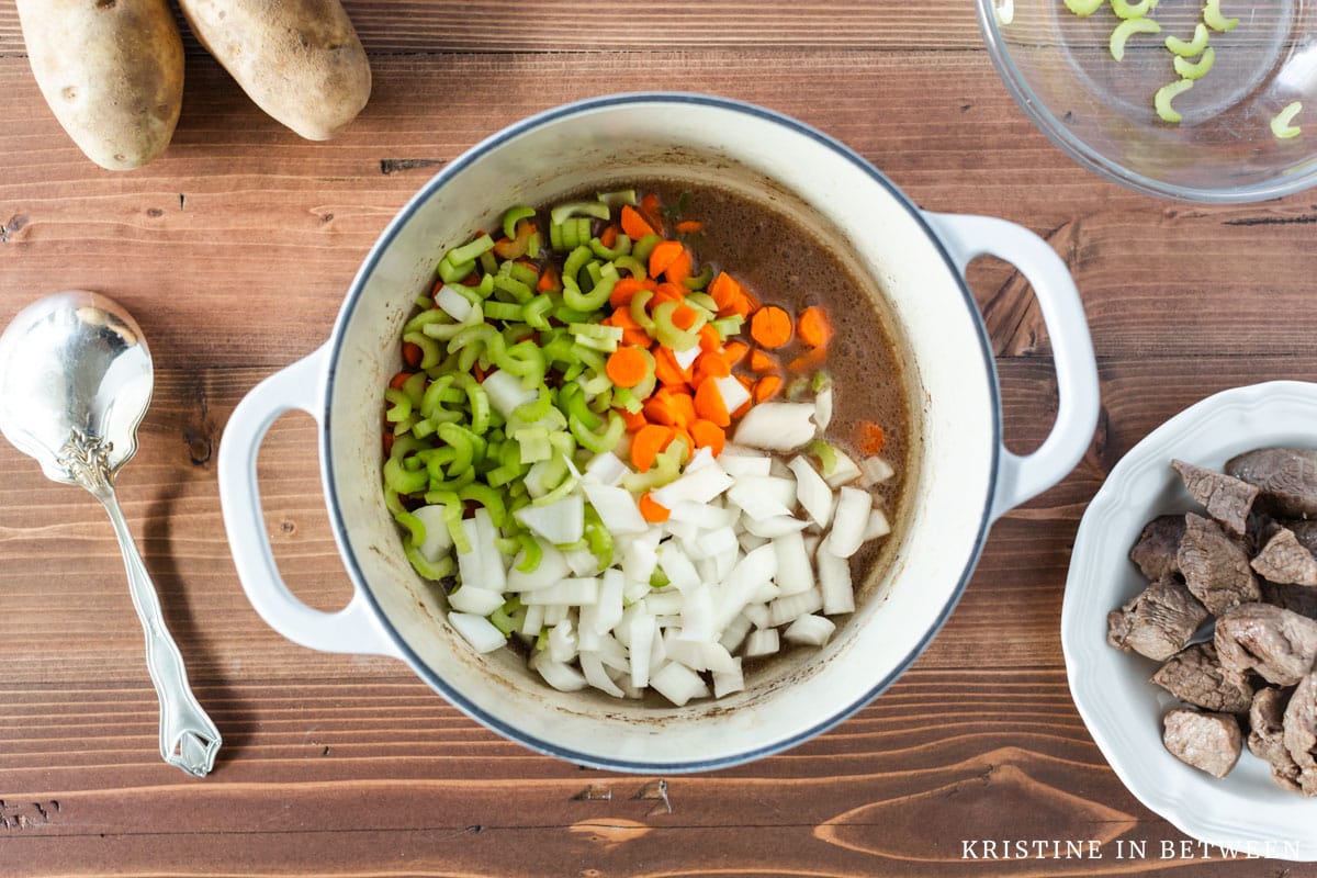 Chopped carrots, celery, and onions in the bottom of a Dutch oven.