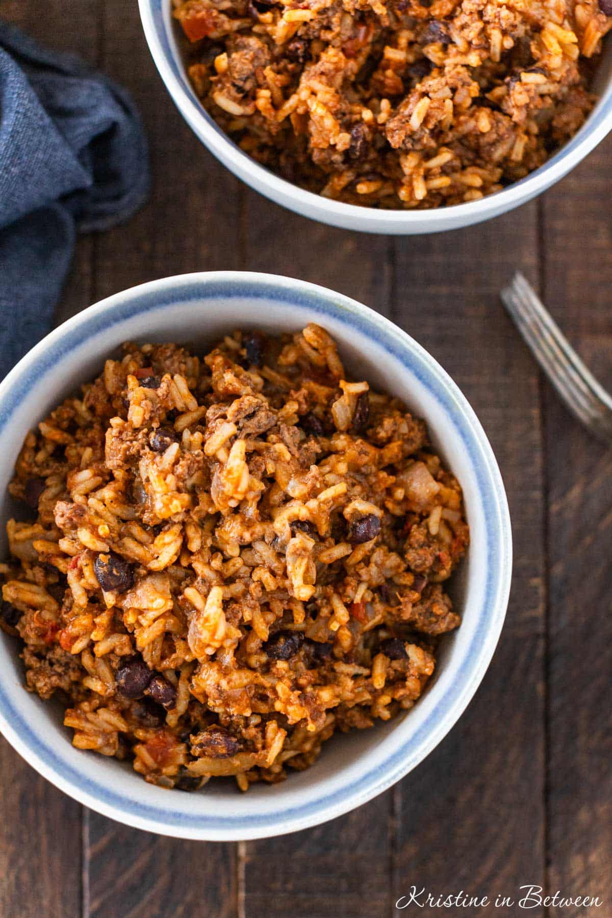 Two bowls of burrito casserole with a fork sitting next to it.