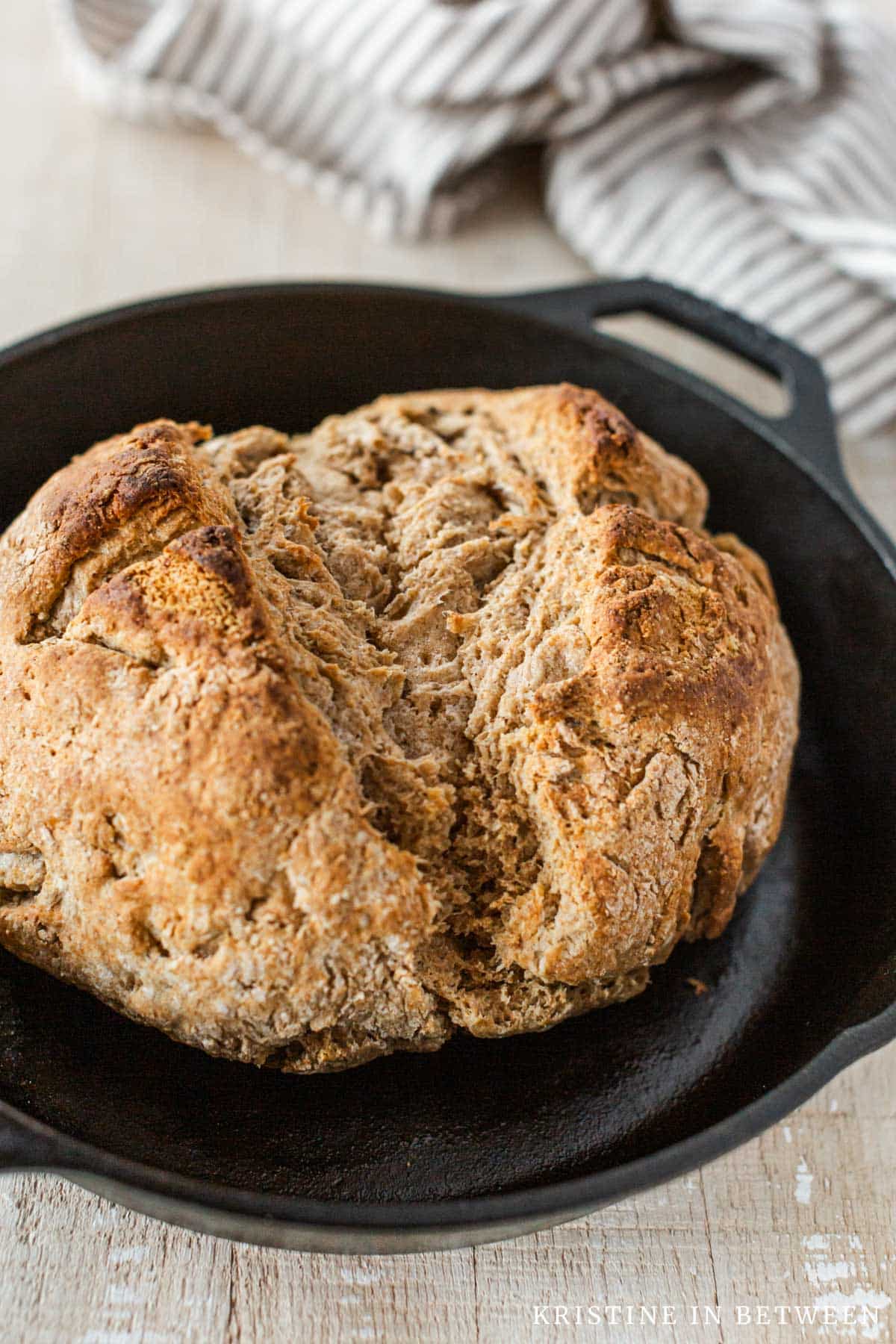 A loaf of Irish brown bread in a cast iron skillet.