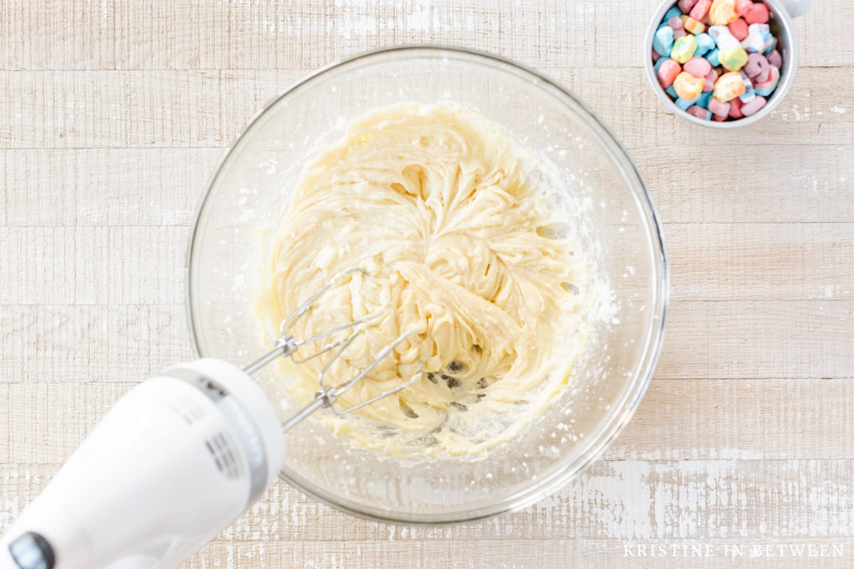 Whipped butter, sugar, and eggs in a glass bowl.