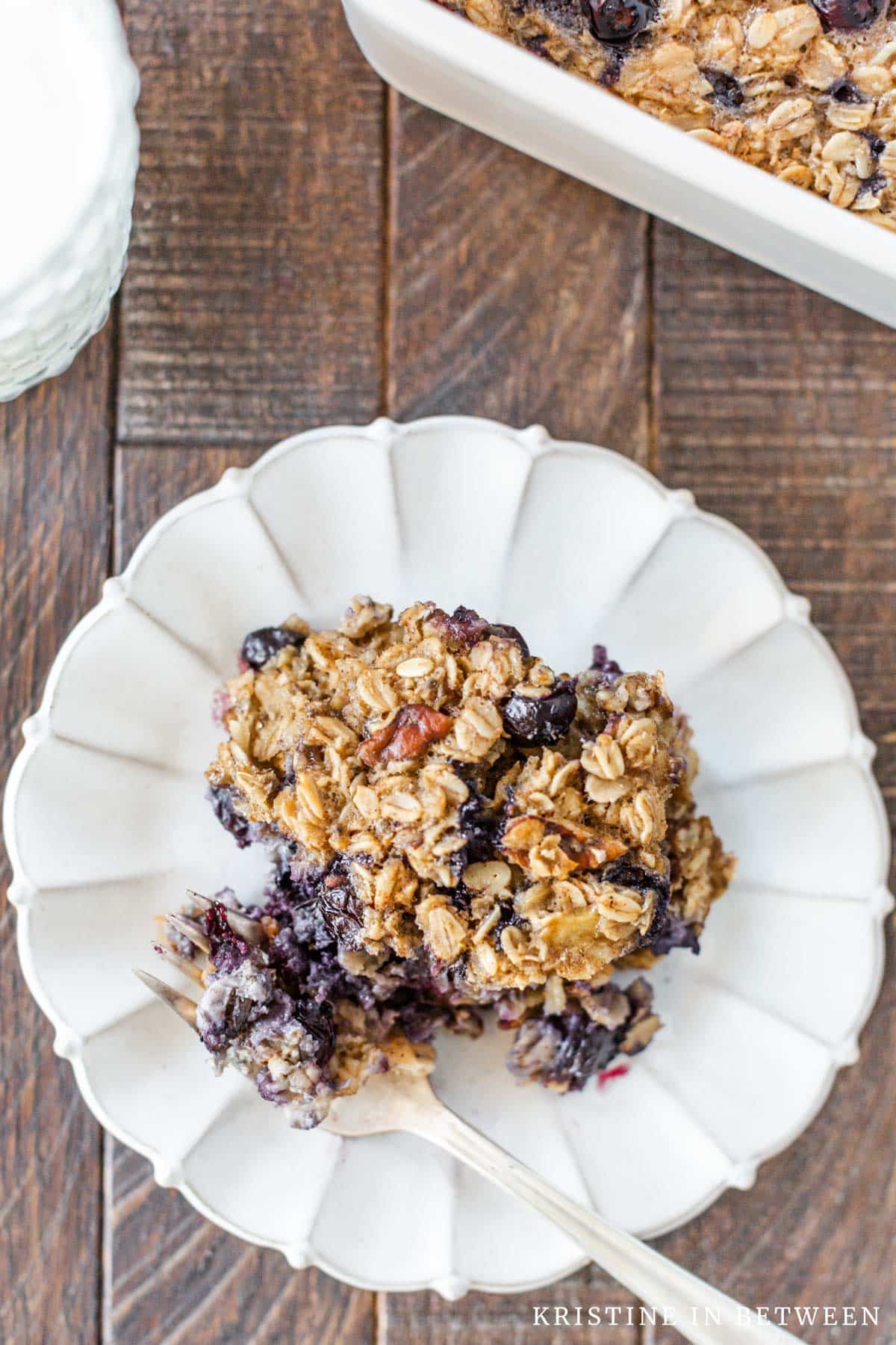 A small plate of baked blueberry oatmeal with a bite on a fork.