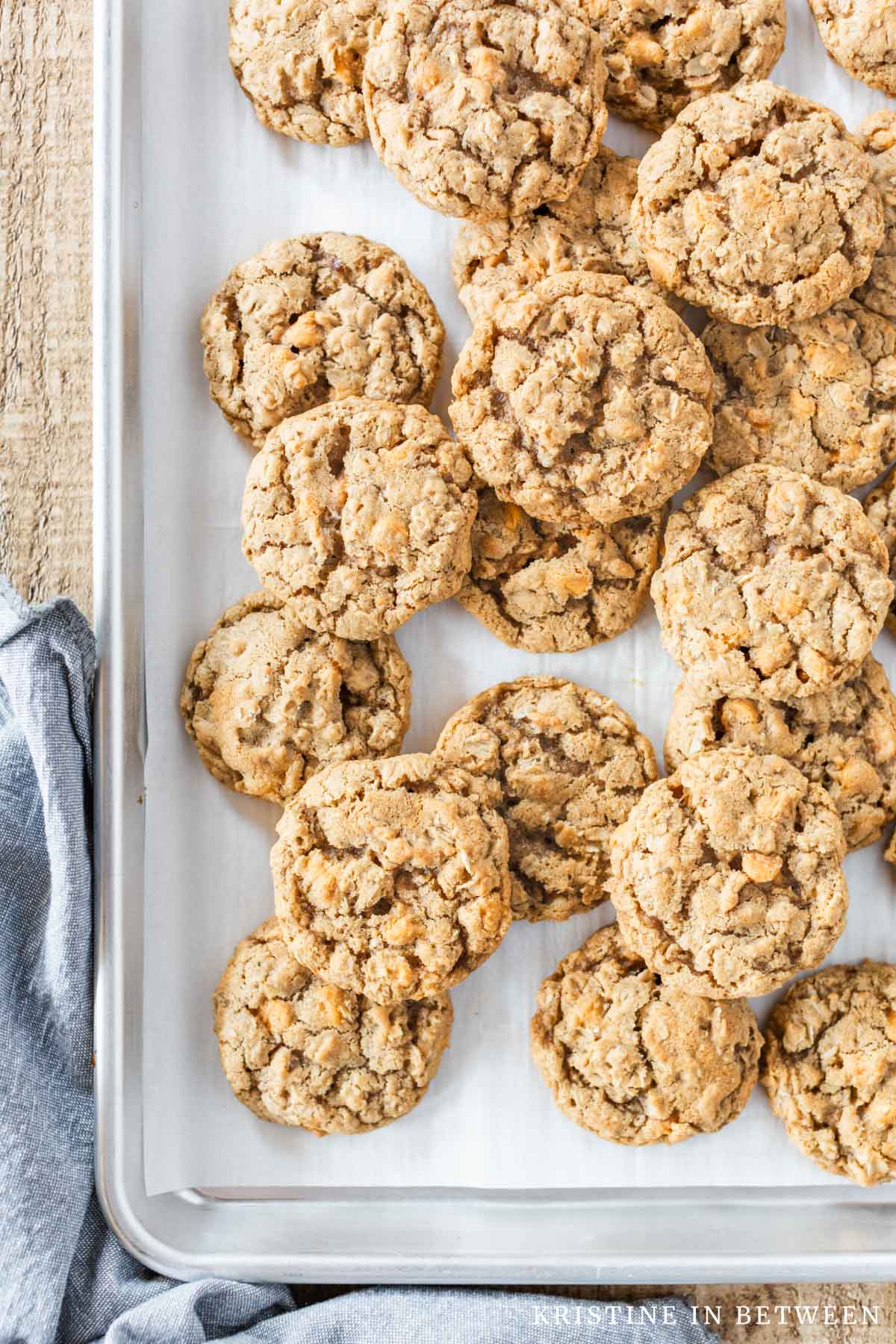 Oatmeal butterscotch cookies laying on a baking sheet lined with parchment paper.