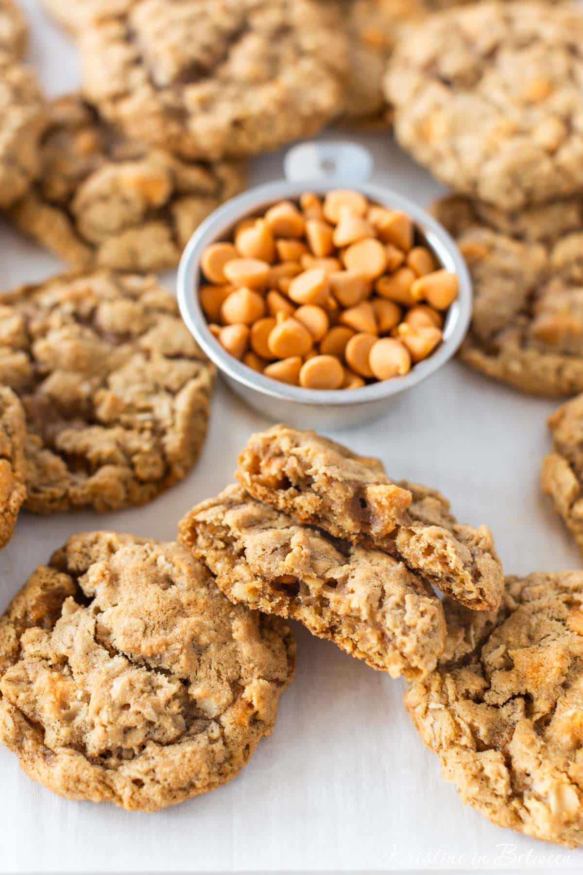 Butterscotch oatmeal cookies laying on a baking sheet with a blue napkin next to them.