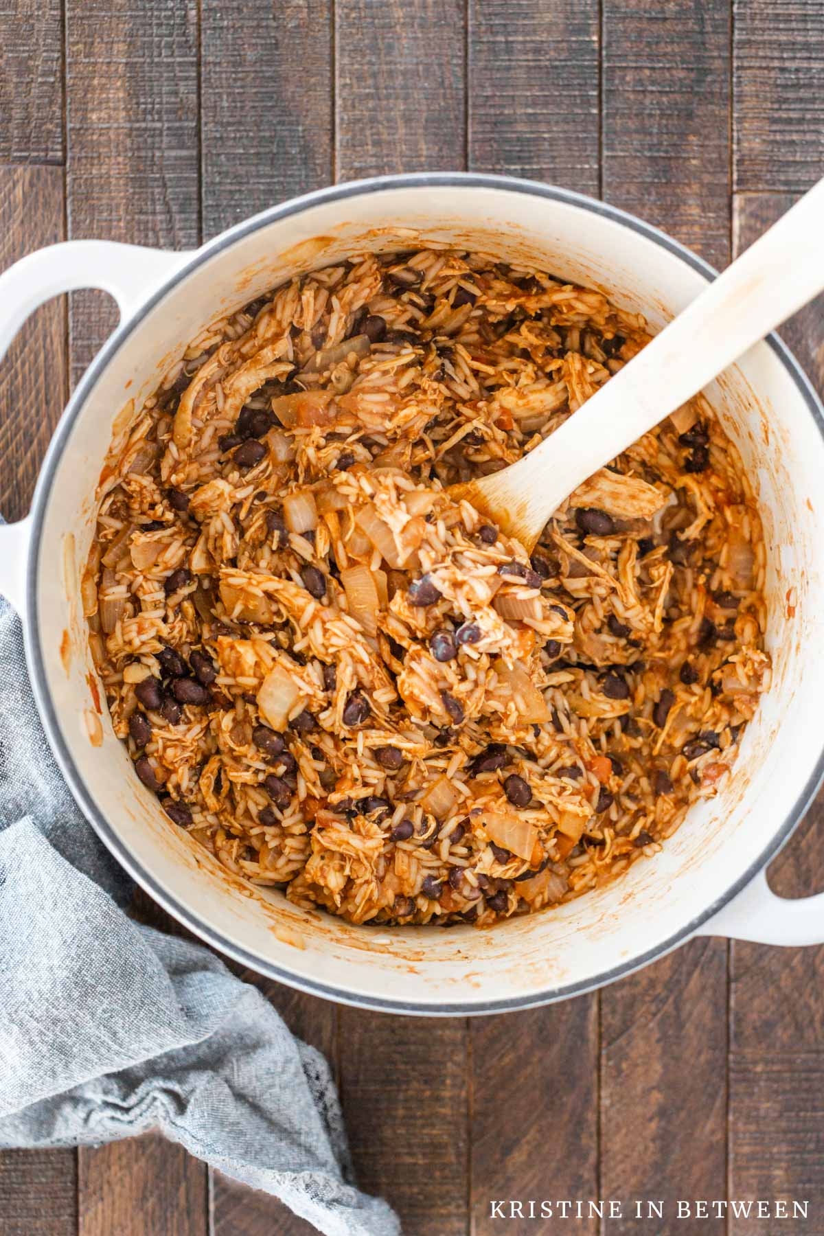 Chicken taco rice casserole in a Dutch oven with a wooden spoon.