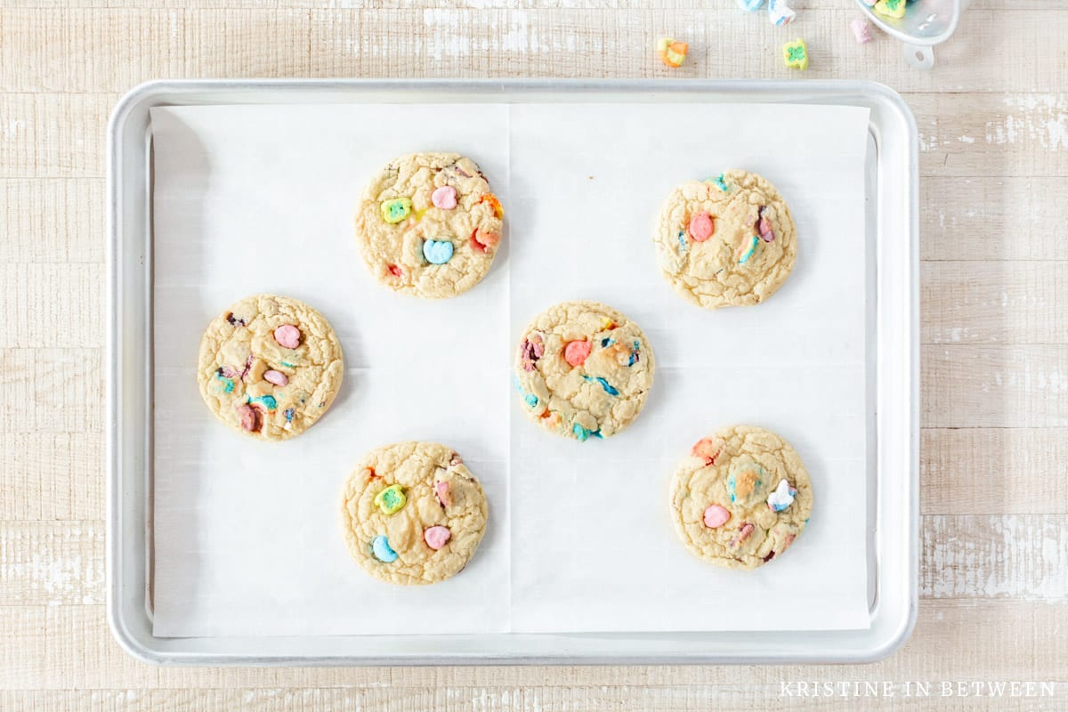 Baked Lucky Charms cookies on a lined baking sheet.