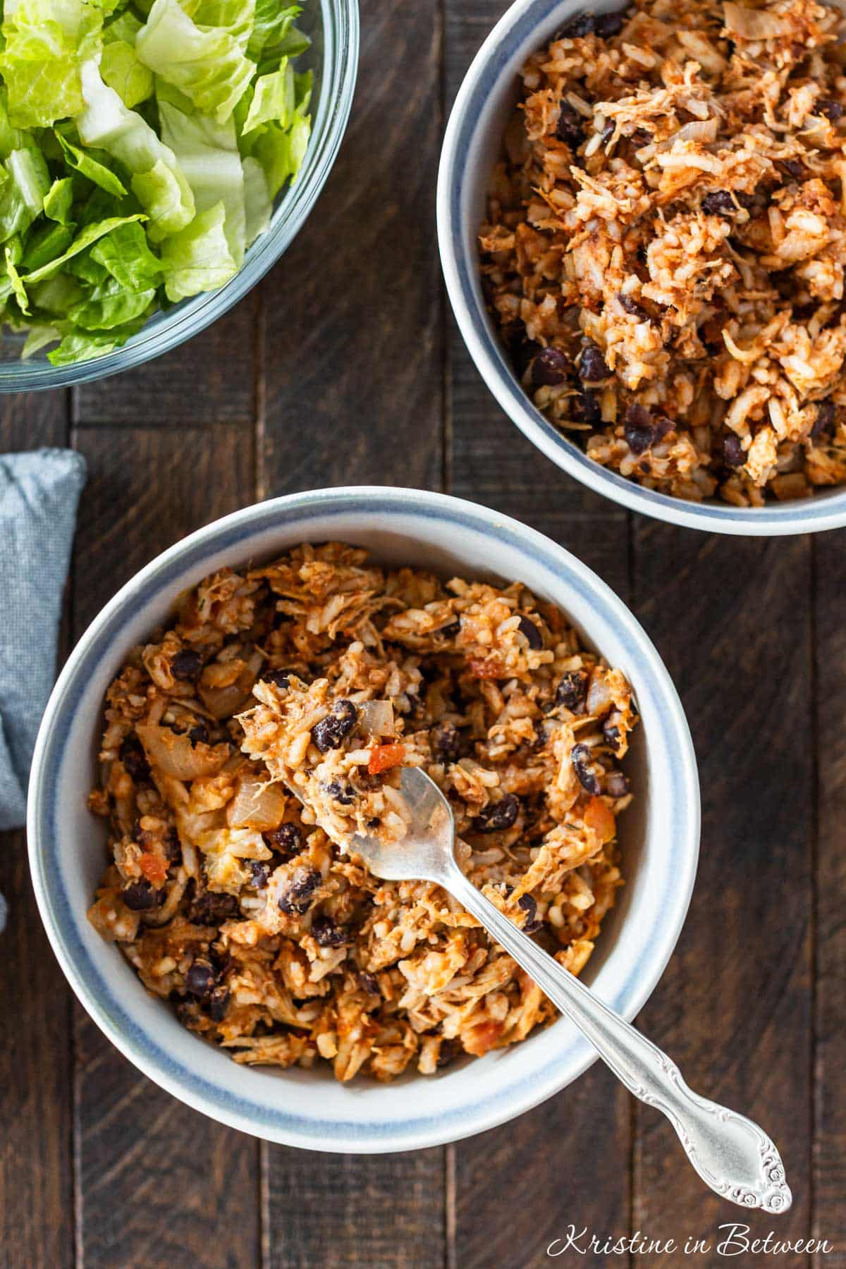 Two bowls of chicken taco rice casserole, one with a bite on a fork ready to eat.
