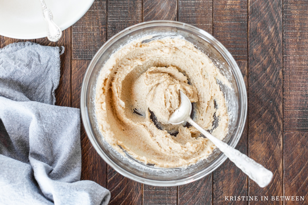 Creamed butter and sugar in a glass bowl with a spoon in it.
