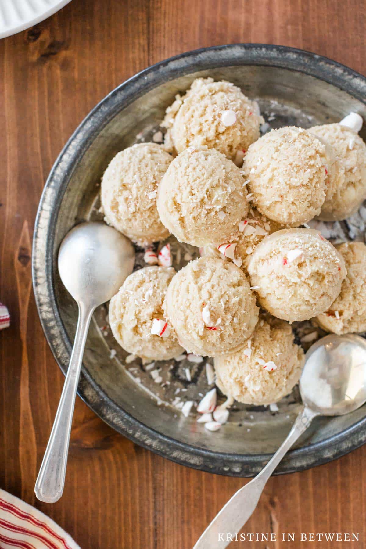 Edible peppermint cookie dough scooped out onto an antique pie plate with two spoons.