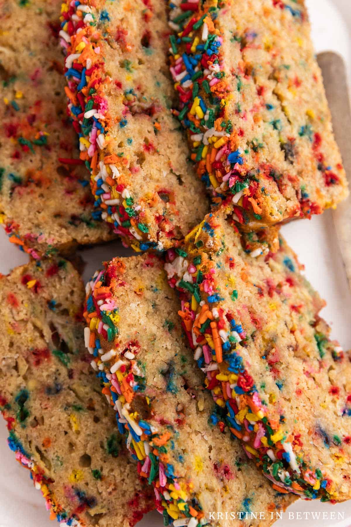 Slices of sugar cookie banana bread laying on a white tray.