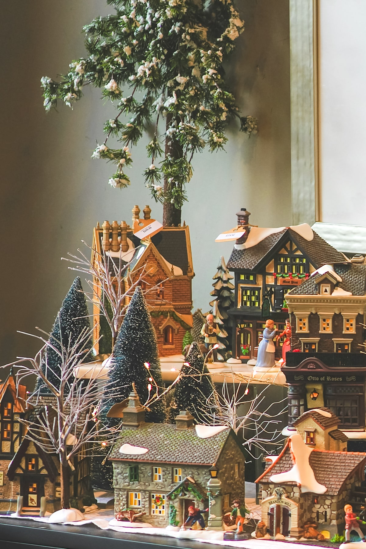 A Christmas village displayed on a console table.
