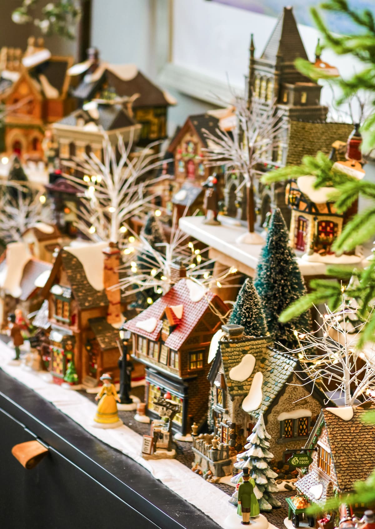 A Christmas village set up on a windowsill.