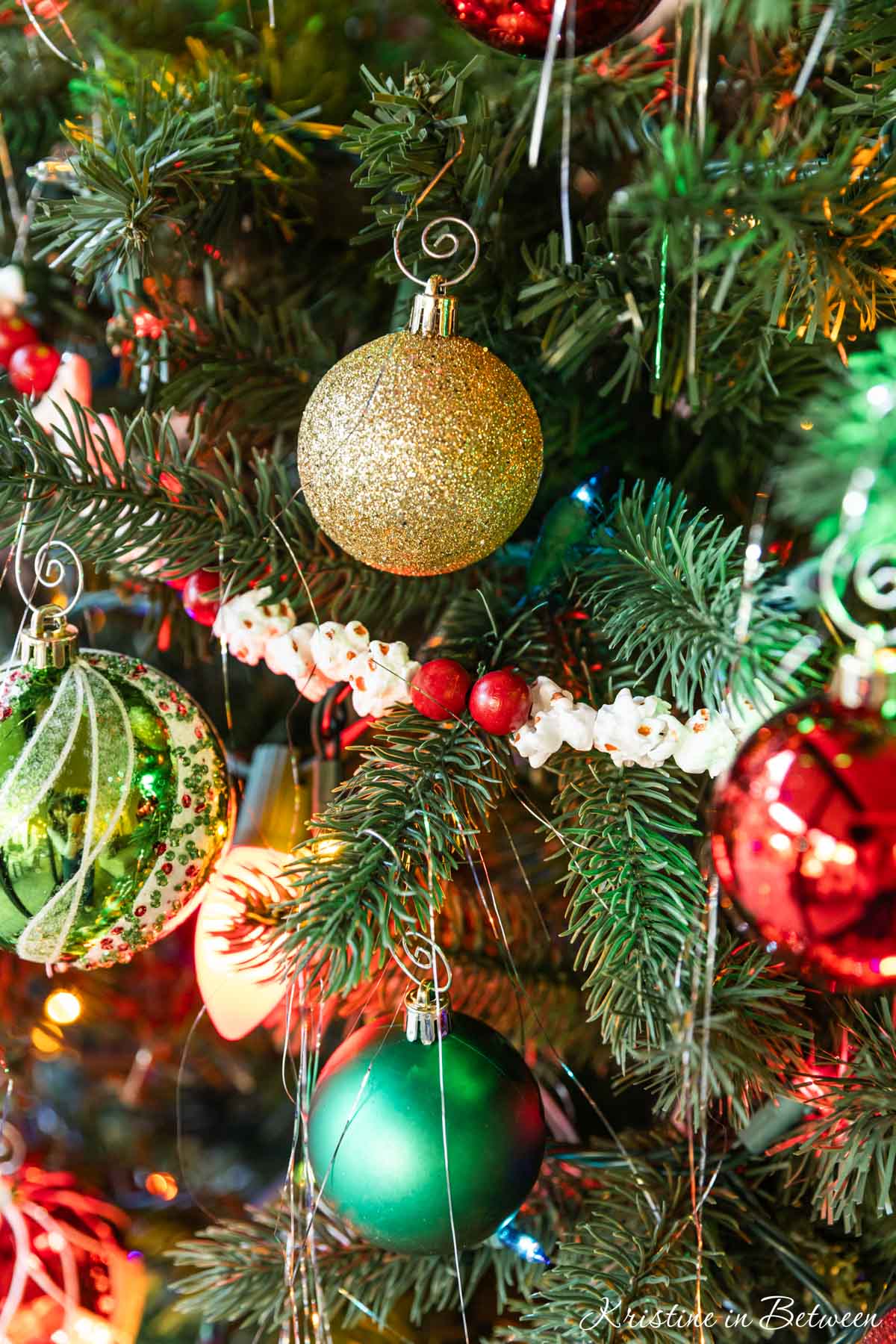Popcorn and cranberry garland around a traditionally decorated Christmas tree.