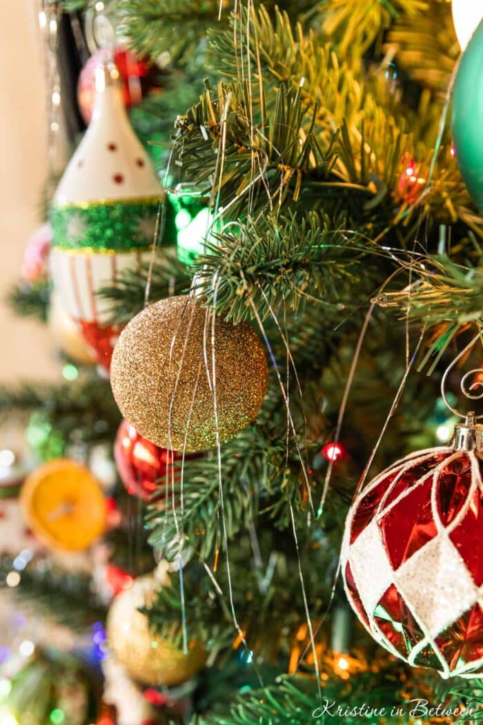 Strands of silver tinsel hanging on a Christmas tree.
